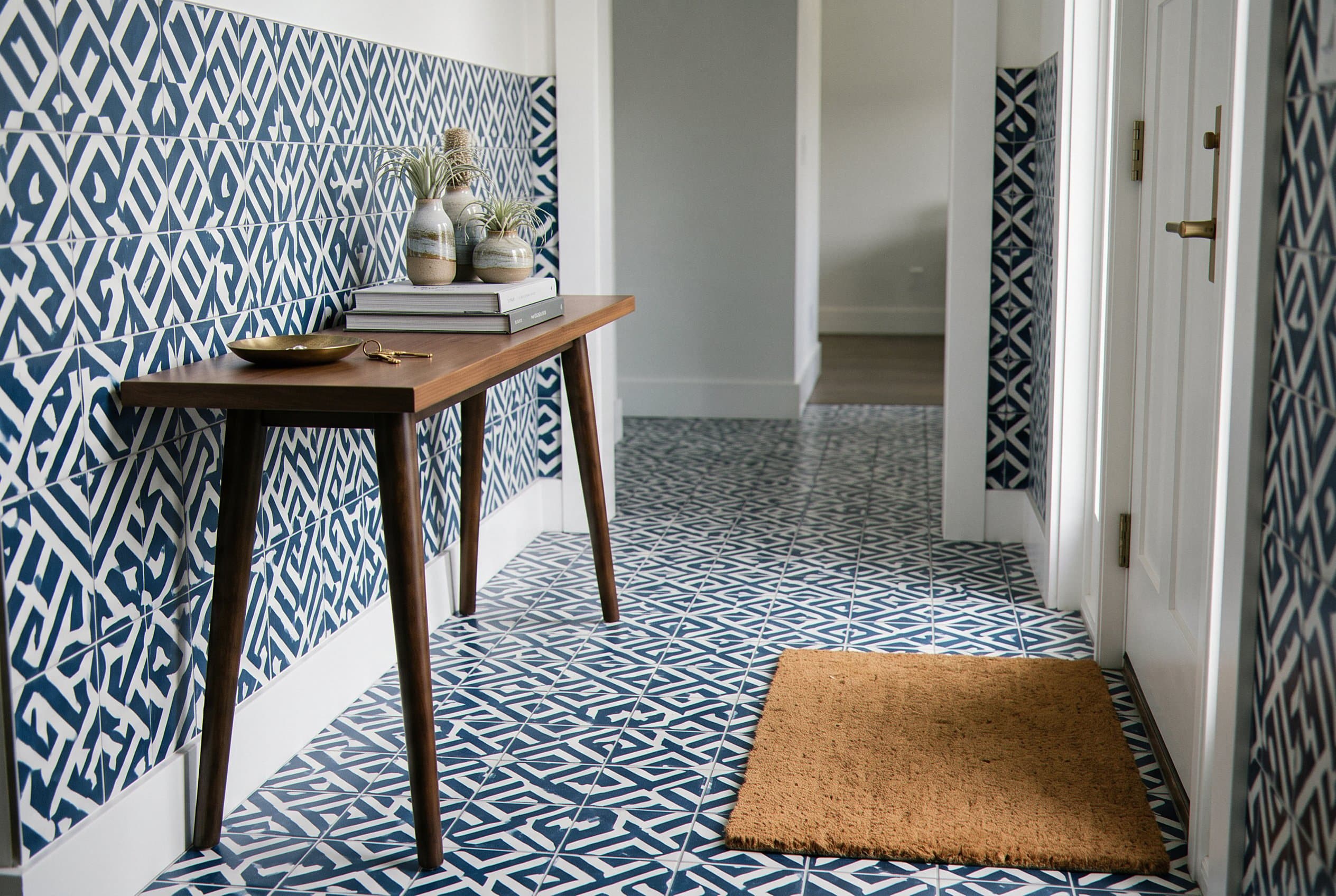 Patterned entry tile floor beneath a console table