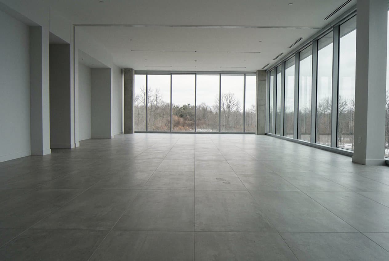 Large-format grey tile floor in a glass-walled room